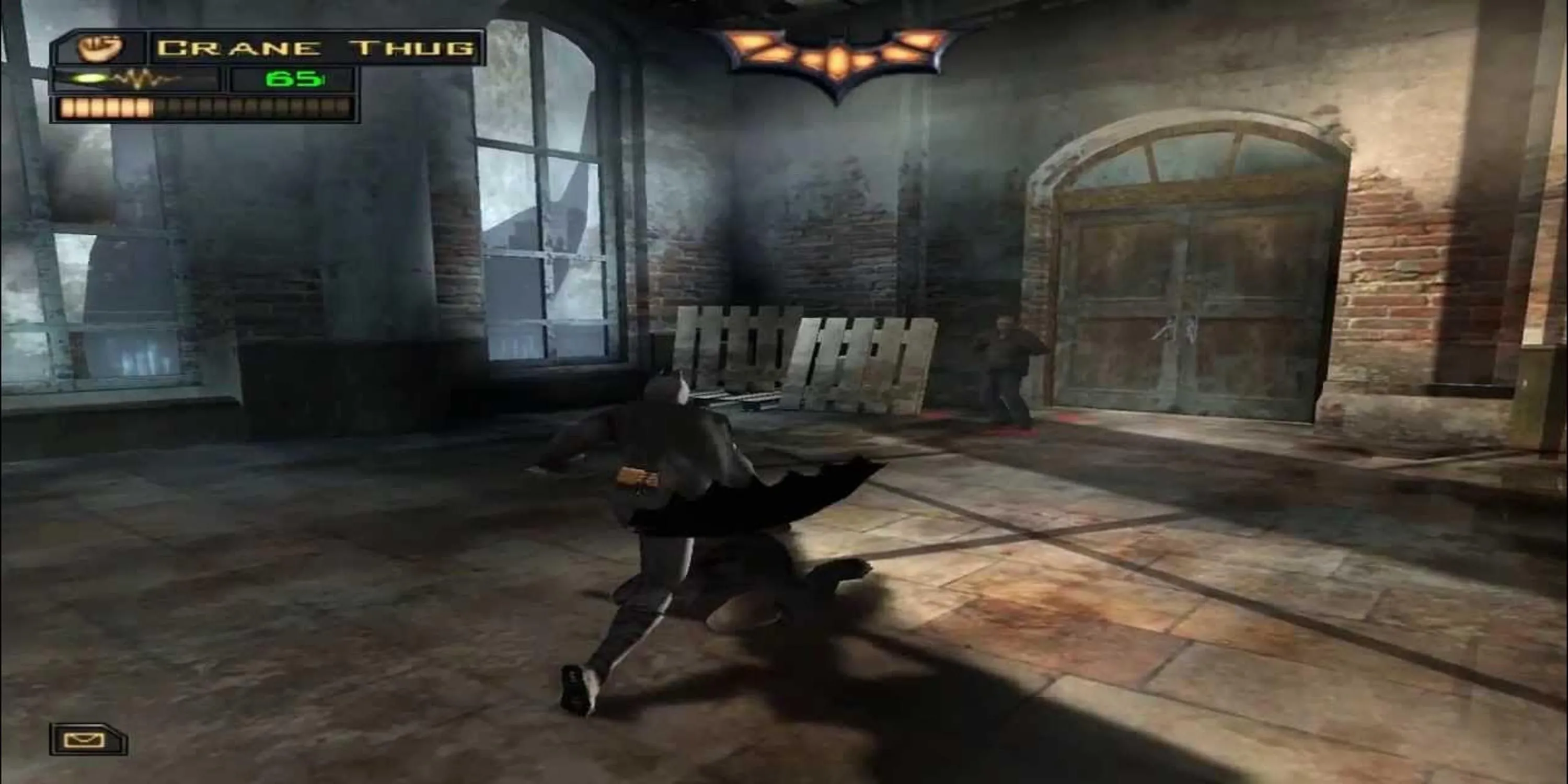 Batman đối mặt với một tên côn đồ trong khung cảnh thành phố đổ nát của Batman Begins, thể hiện yếu tố kinh dị tâm lý.